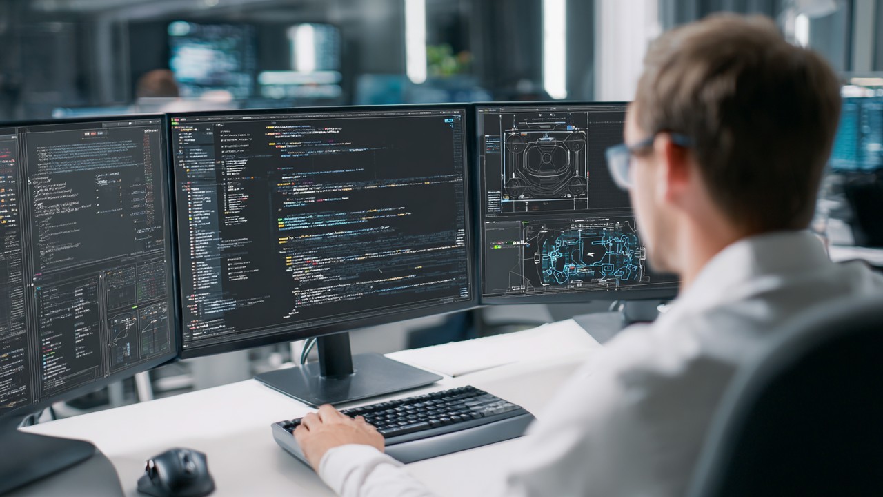 Web geliştirici, modern ofiste çoklu ekranlarda CDN ayarlarını yapılandırıyor, kodlama ve ağ diyagramlarıyla teknik kurulum yapıyor.